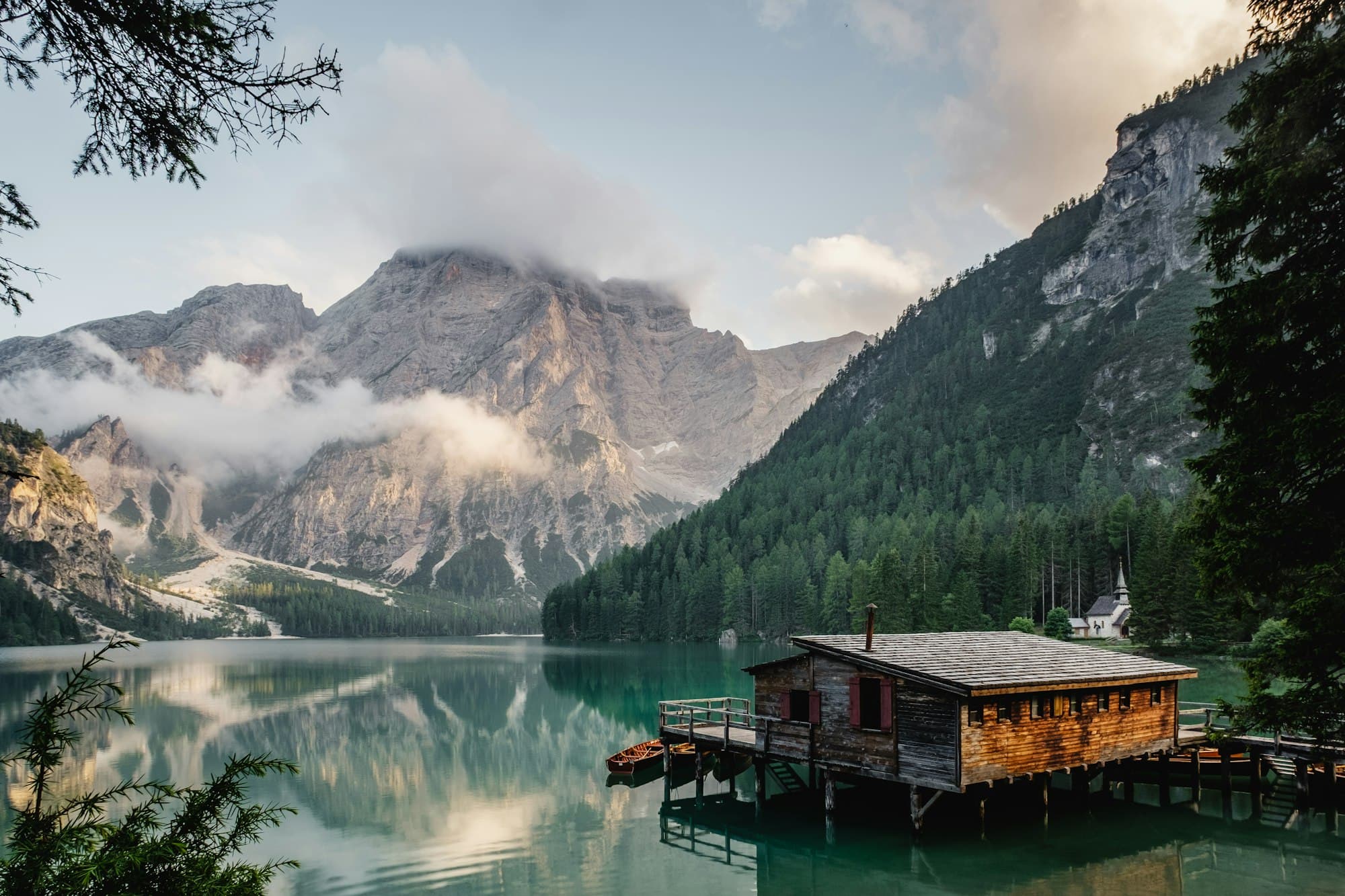 Lakeside boathouse among forested mountains